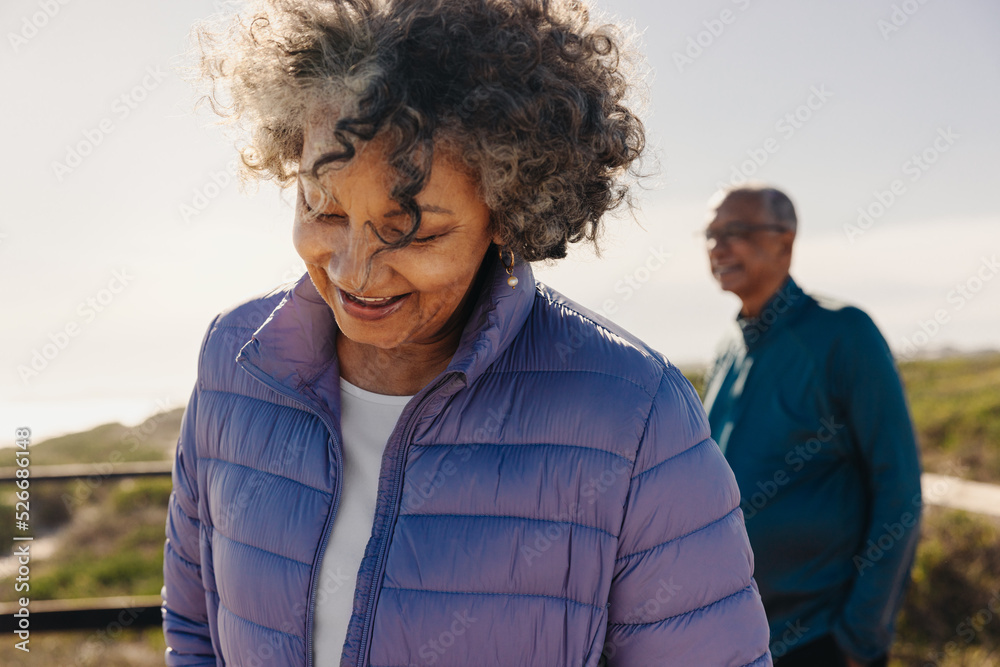 Senior woman smiling happily while standing on a foot bridge