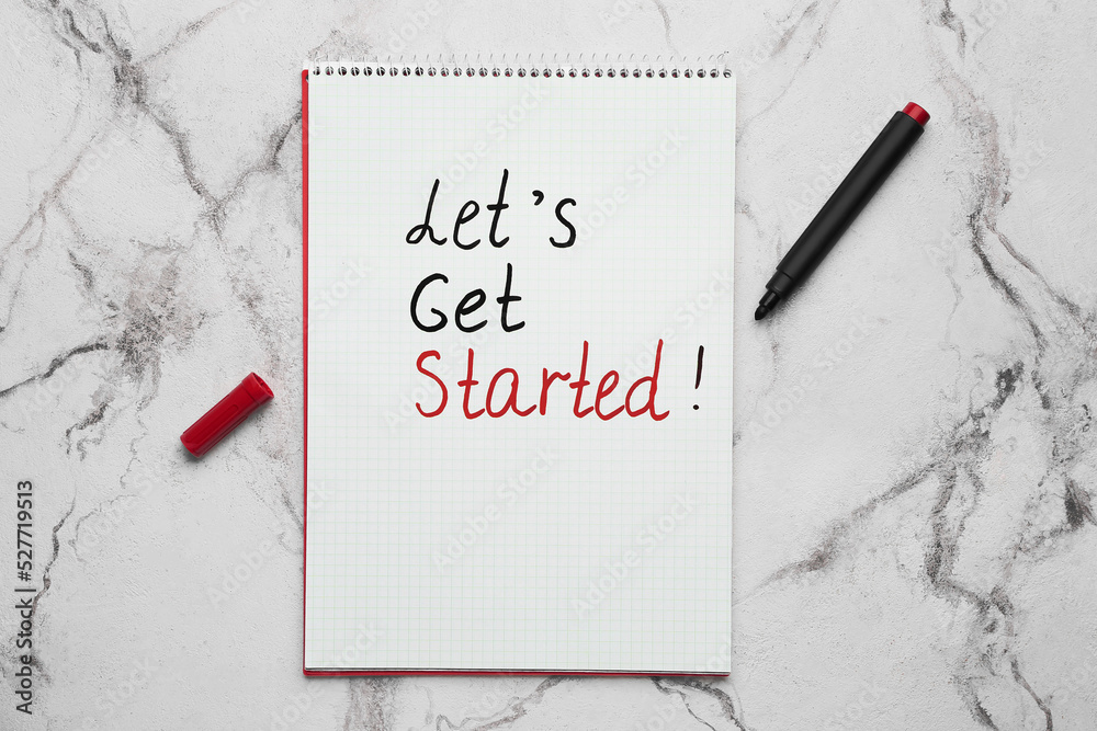 Notebook with text LETS GET STARTED and marker on white background