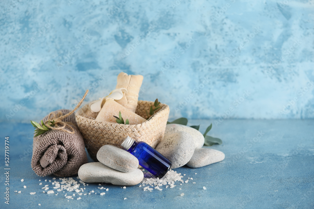 Spa composition with clean towel and stones on color background