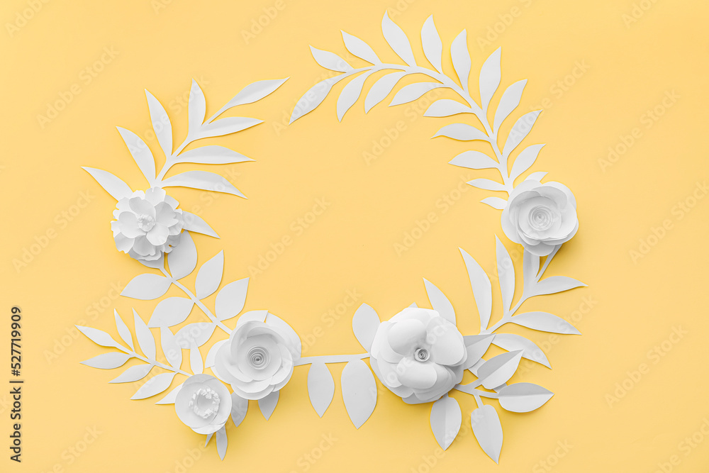 Frame made of paper flowers with leaves on yellow background