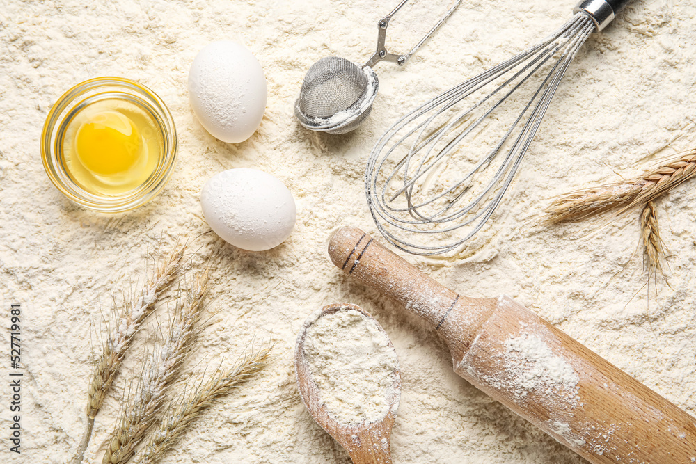 Composition with ingredients and utensils for baking on flour background