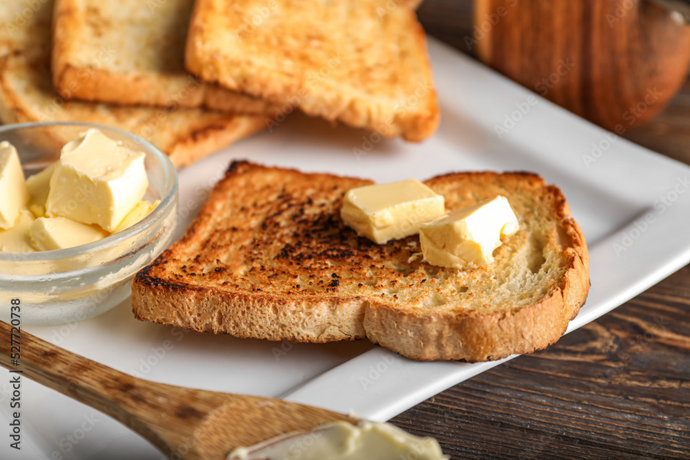 Plate with slice of toasted bread and butter, closeup