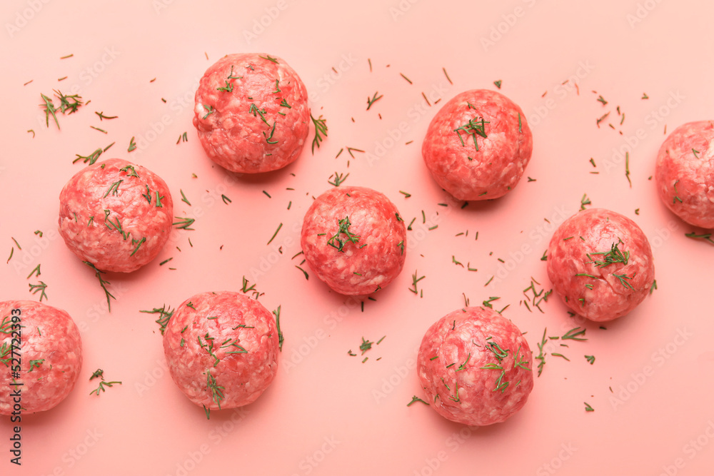 Raw meat balls with cut dill on pink background