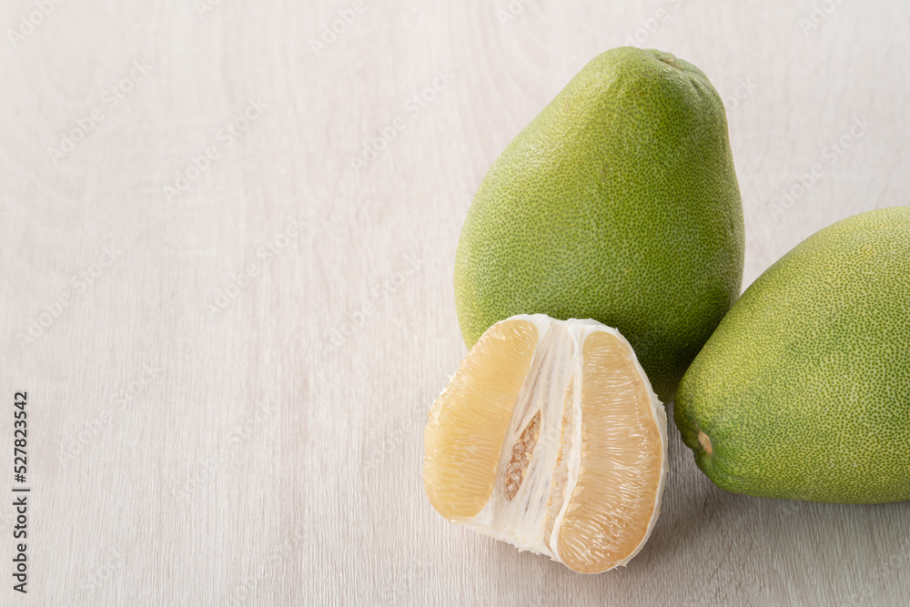 Fresh pomelo fruit on wooden table background.