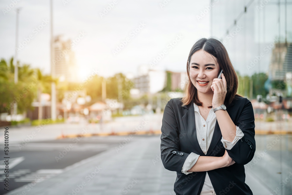 亚洲女性在航站楼门口用智能手机等候。年轻休闲商务人士的航空旅行理念