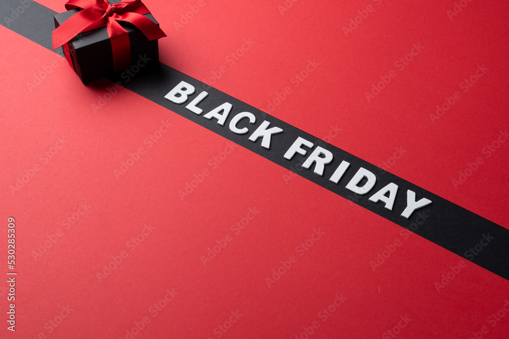 Composition of present with pink ribbon and black friday text on gray and pink background