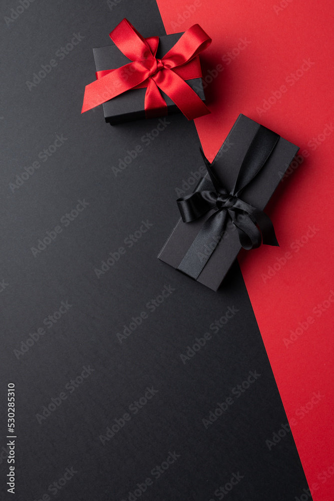 Composition of presents with pink and black ribbons on gray and pink background