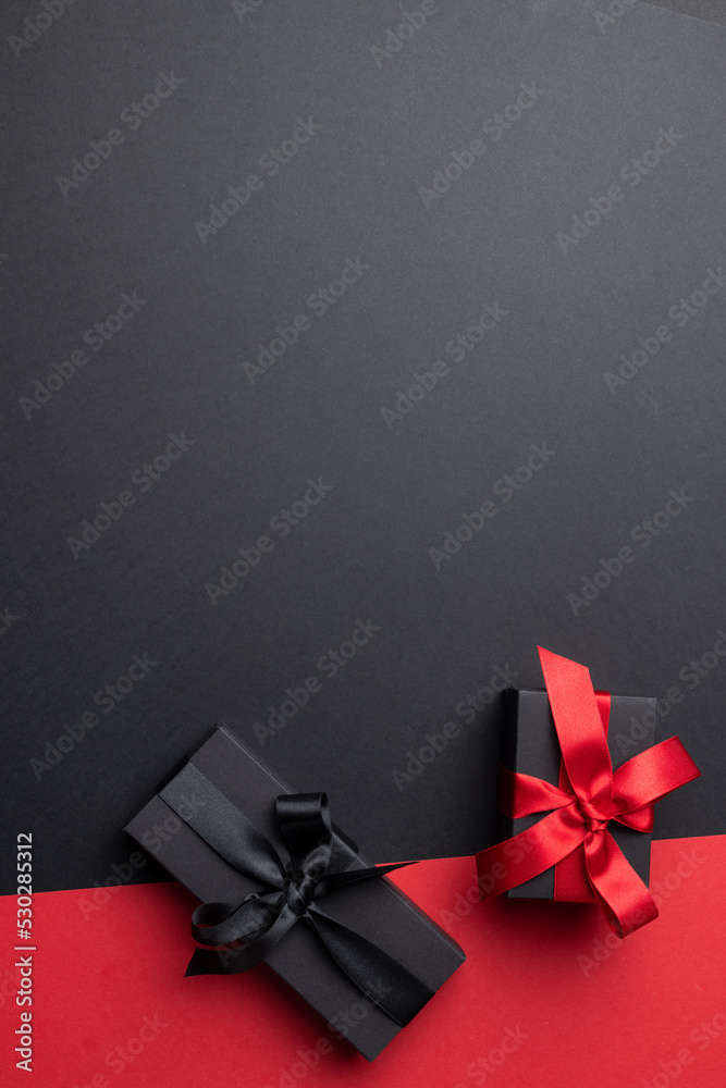 Composition of presents with pink and black ribbons on gray and pink background