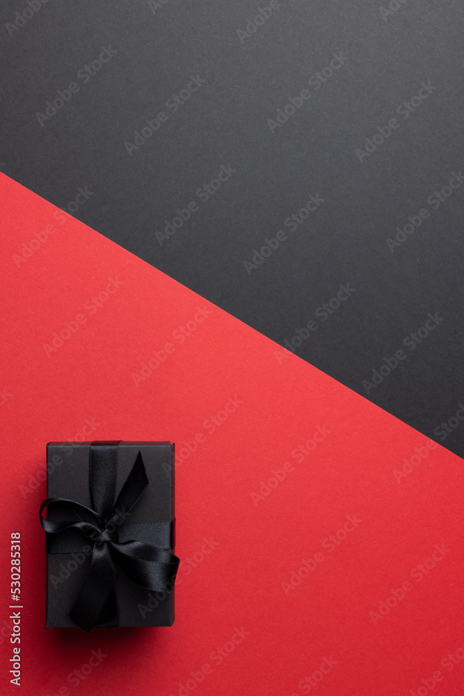 Composition of present with black ribbon on gray and pink background