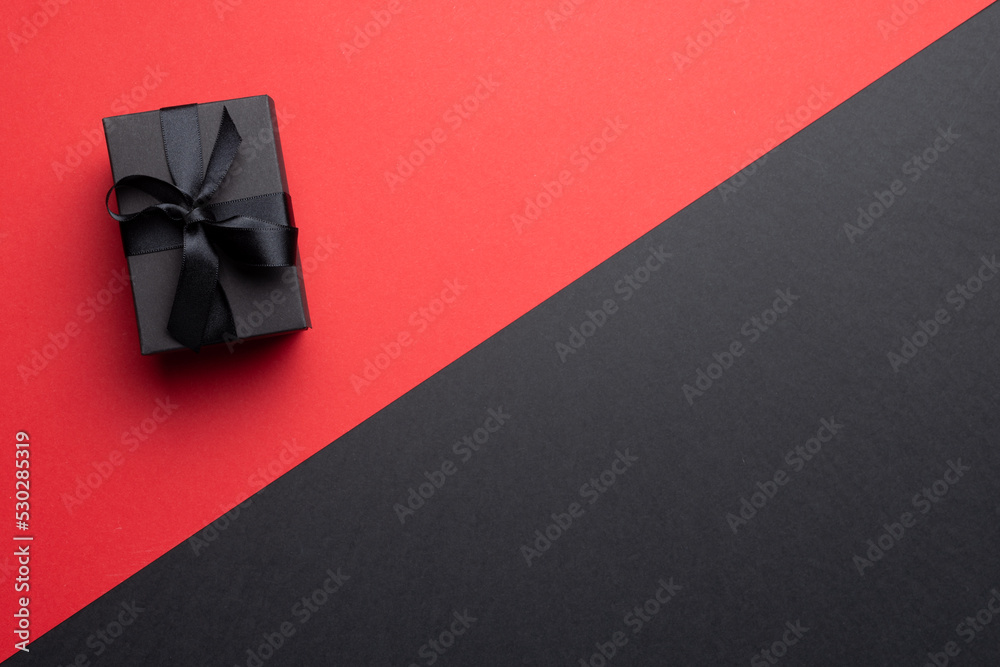 Composition of present with black ribbon on gray and pink background