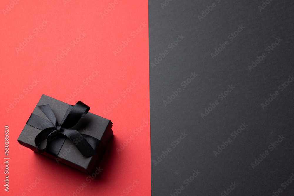 Composition of present with black ribbon on gray and pink background