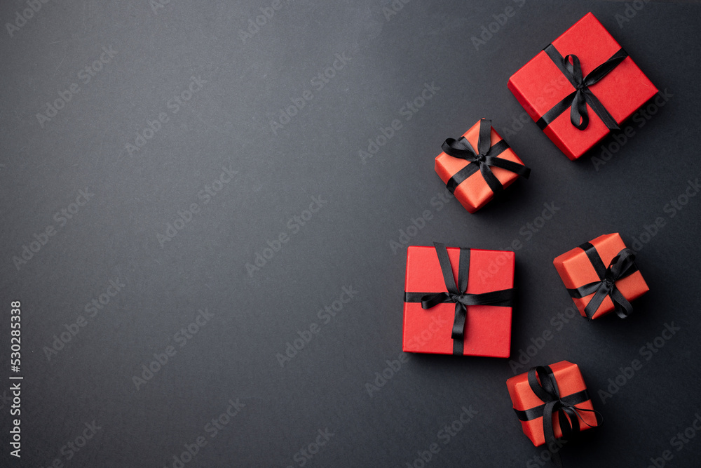 Composition of presents with black ribbons on gray background