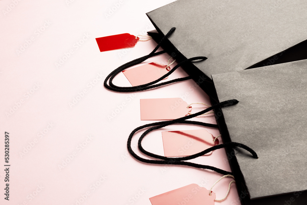 Composition of gift tags and bags with copy space on white background