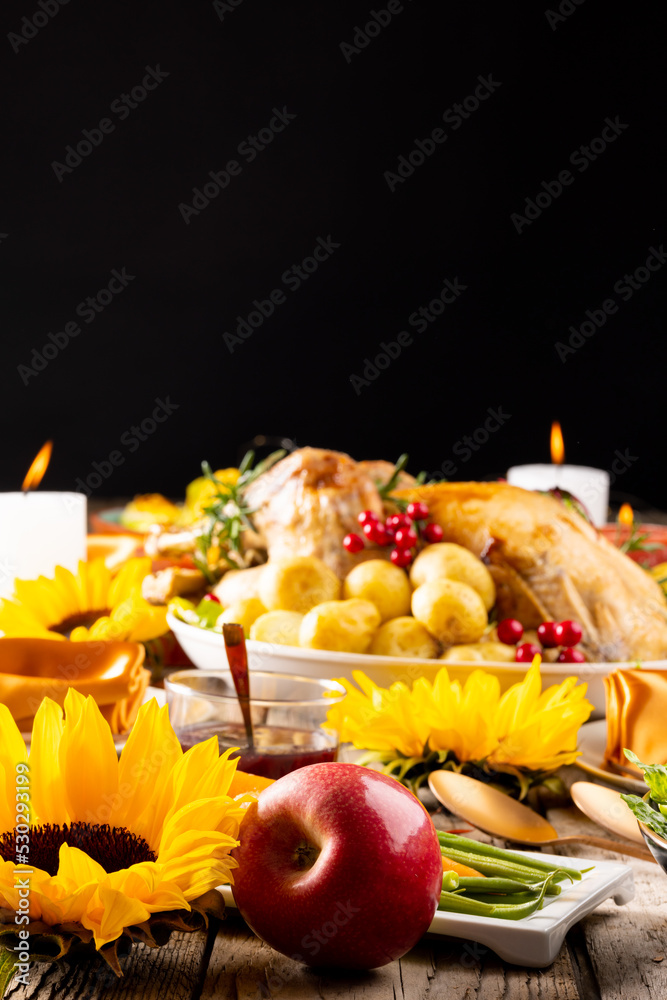 Close up of thanksgiving table with roast turkey, potatoes, candles and autumn decoration