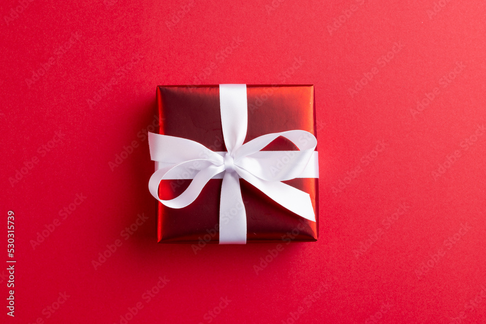 Image of red christmas gift decoration and copy space on red background