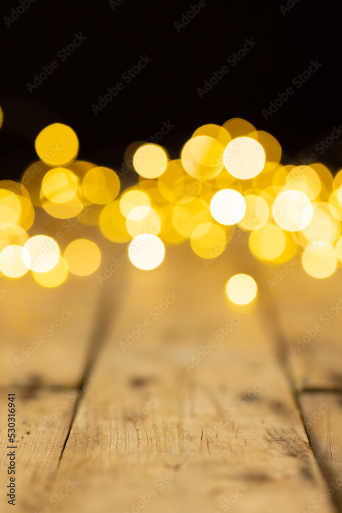 Image of christmas out of focus fairy lights and copy space on wooden background