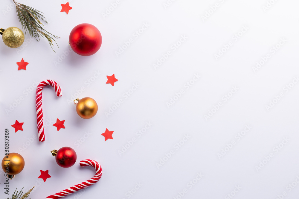 Christmas cane, gifts, christmas tree twigs and red stars over white background