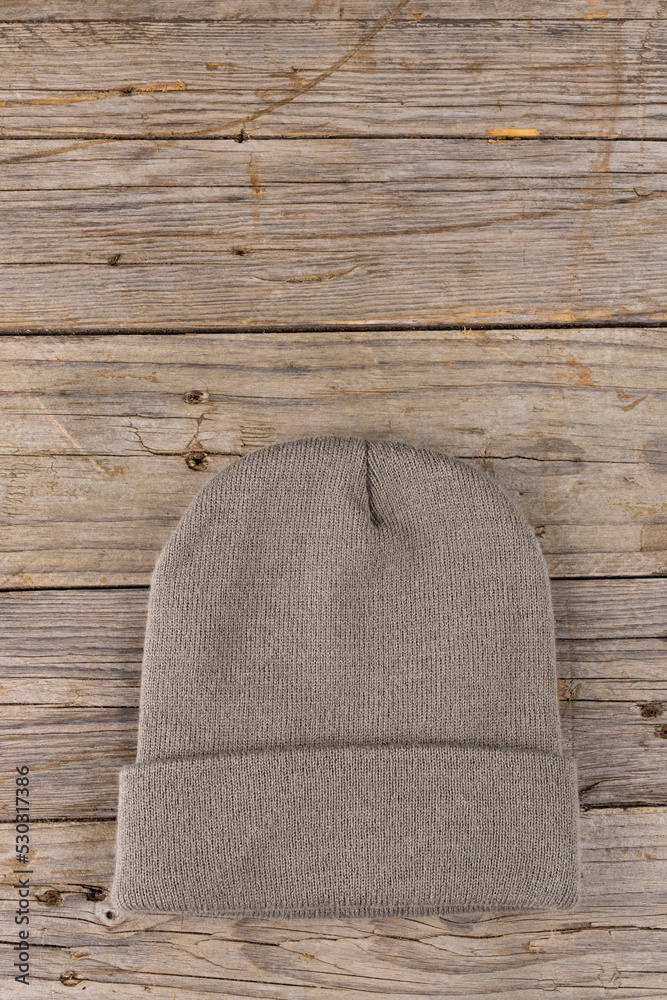 Vertical image of wool beanie lying on wooden surface