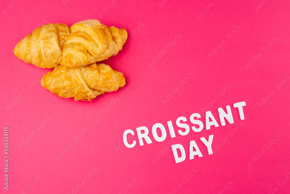 Image of croissants and croissant day on pink background