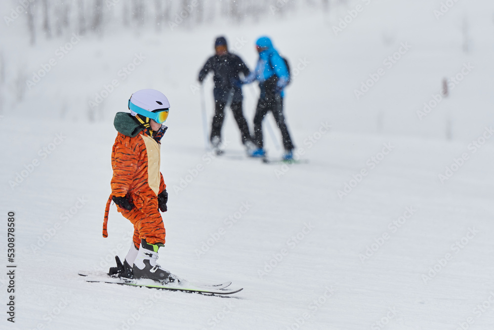 穿着老虎服装的孩子正在滑雪