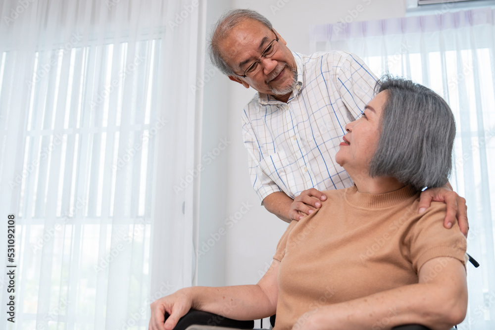 A contented senior couple and their in-home nurse. Elderly female in wheelchair with her young careg