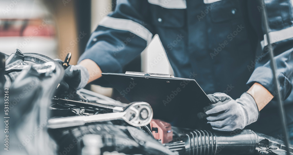 Mechanic works on the engine of the car in the garage. Repair se