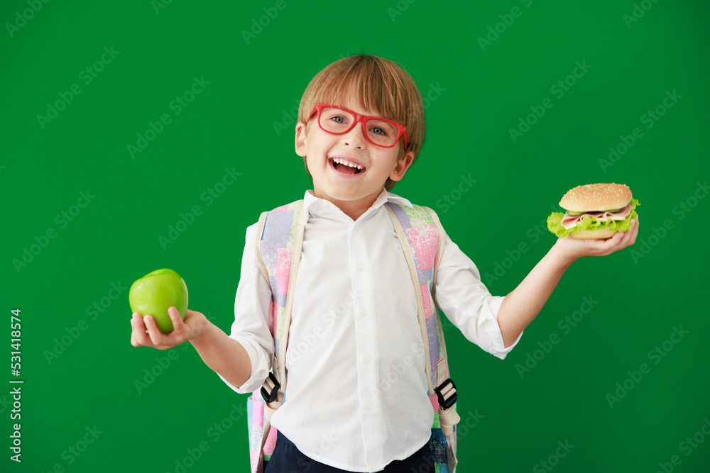 Happy child student against green chalkboard