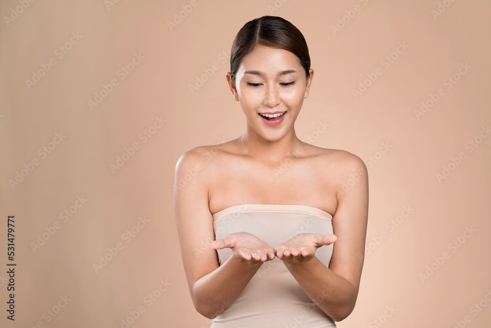 Portrait of ardent woman looking at camera, holding empty space for product, advertising text place,