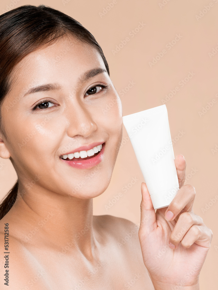 Ardent woman smiling holding mockup product for advertising text place, light grey background. Conce