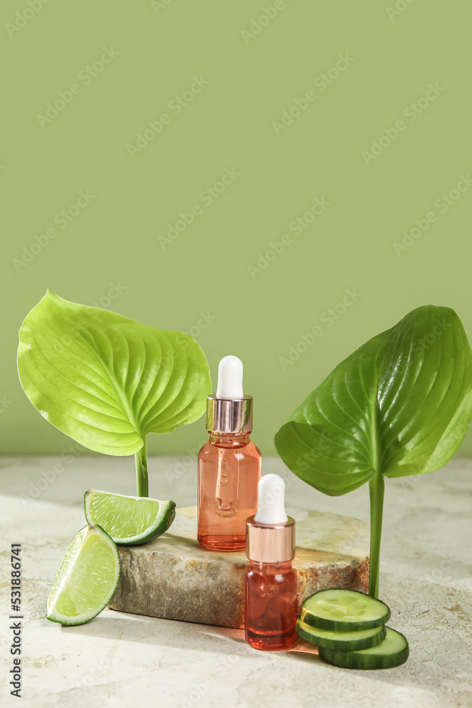 Bottles of essential oil and cucumber slices on table