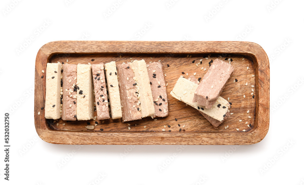 Wooden board with pieces of delicious sesame halva on white background