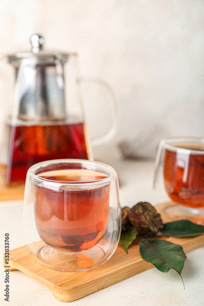 Board with glass of puer tea on white background, closeup