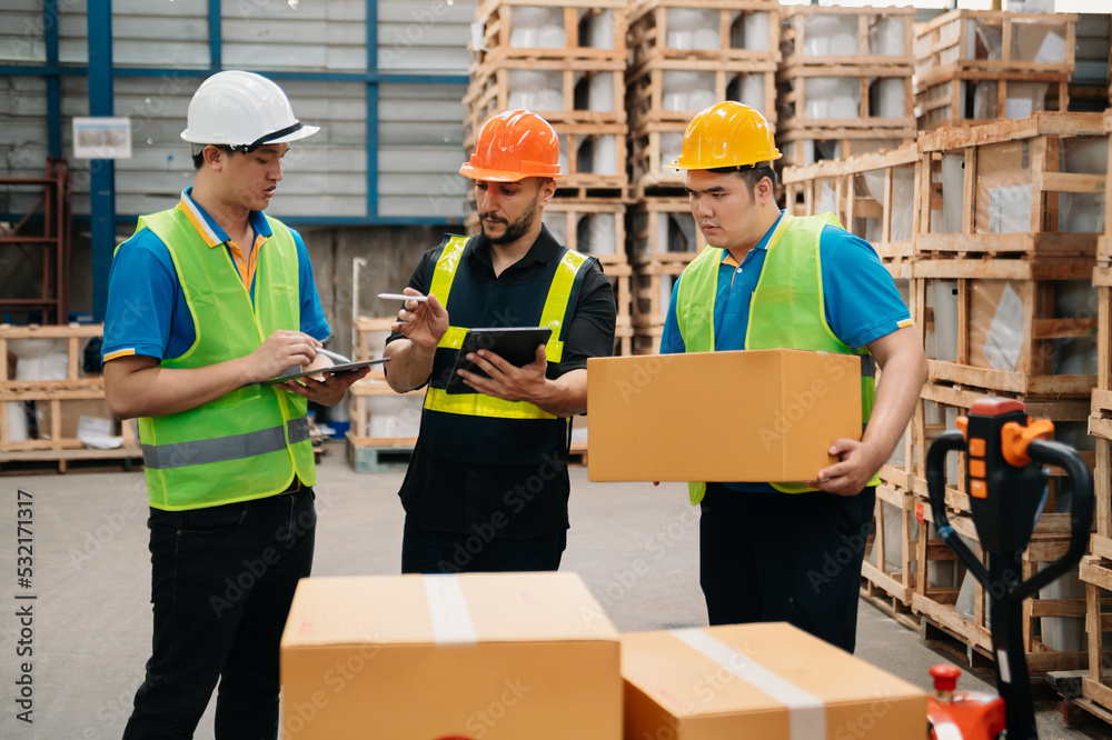 Management having discussion at warehouse with hardhat using digital tablet Working in Logistics and