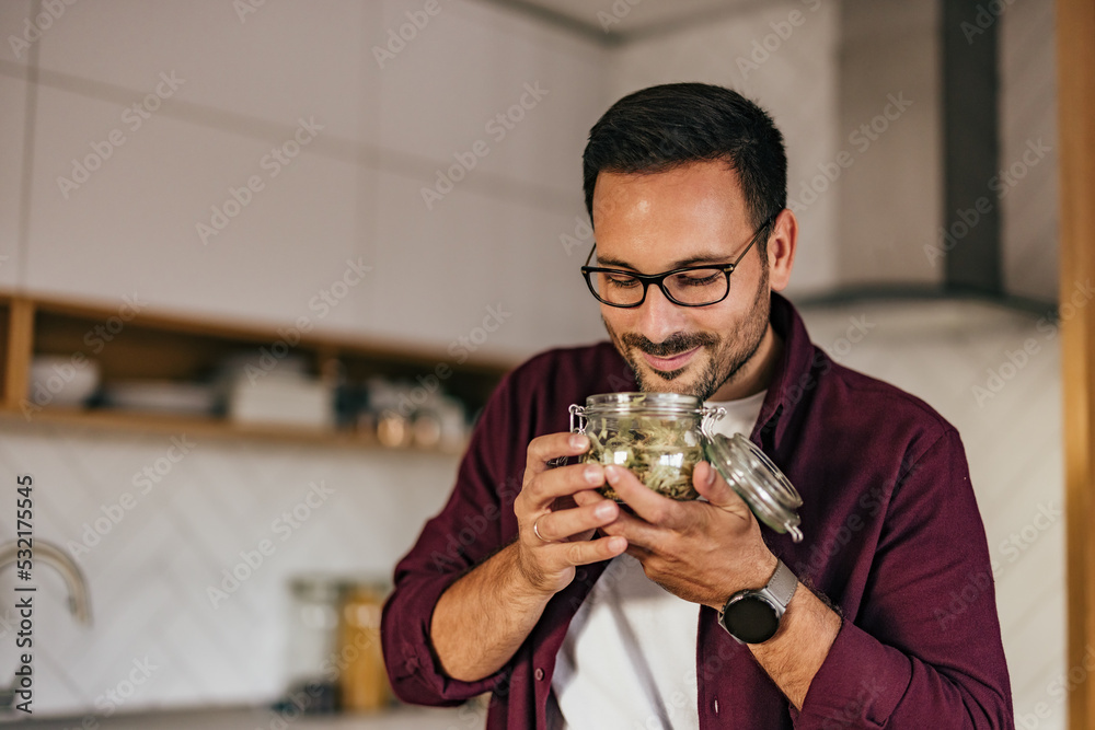 一个微笑的男人的照片，从杯子里闻到了一份茶单。