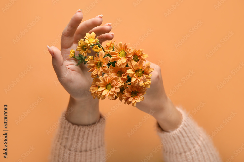 橙色背景下开着美丽菊花的女人，特写