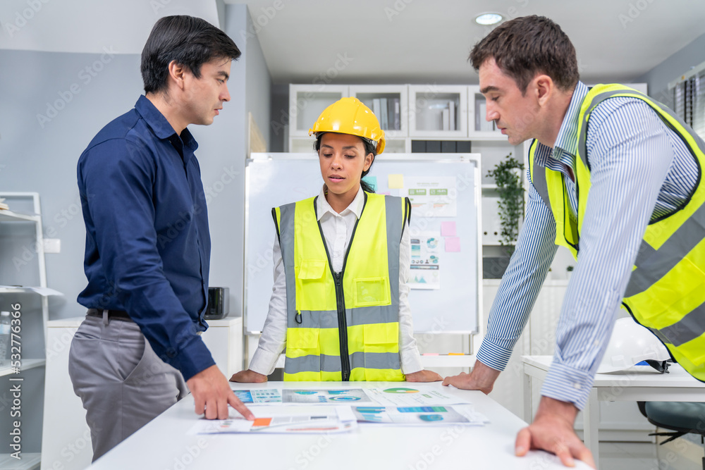 A group of competent engineers and employer discuss plans in the office. Architectural investor, bus