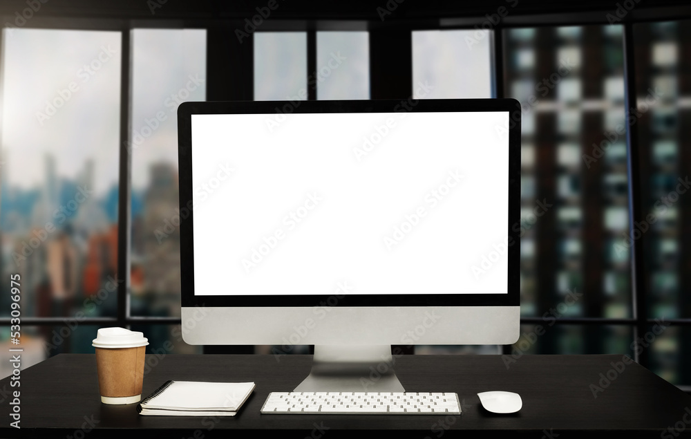 Workspace computer putting on wood working desk and surrounded by coffee cup, clipboard, potted plan