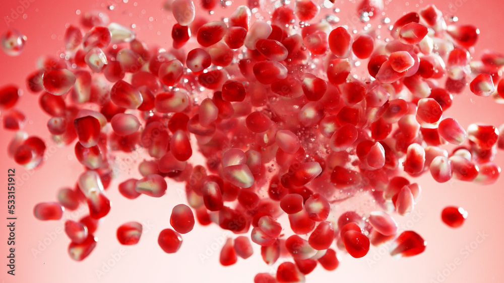 Sweet pomegranate seeds splashing underwater.