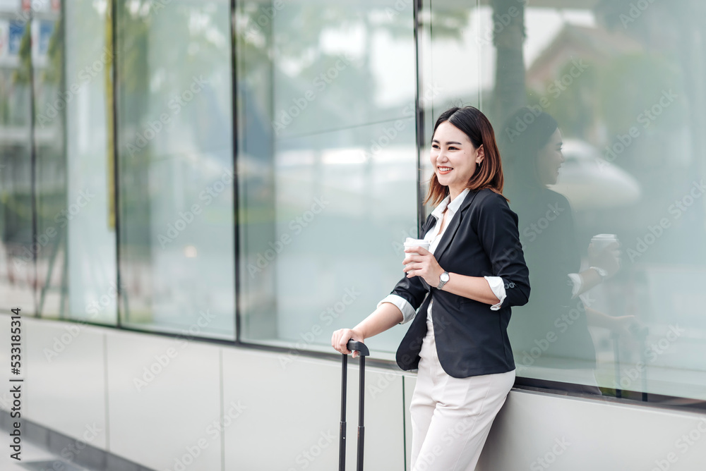 Young Asian businesswoman talking on phone and sitting in airport before business trip. Beautiful wo