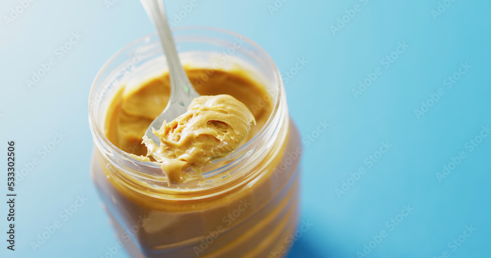 Image of close up of peanut butter on blue background