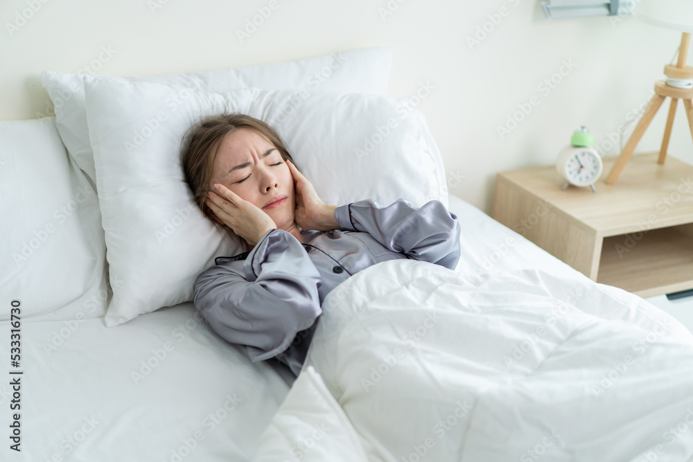 Caucasian beautiful frustrated girl in pajamas sleep on bed in morning