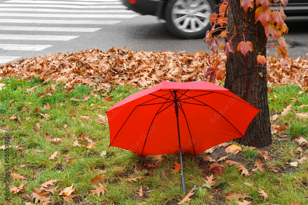 Bright umbrella on autumn street