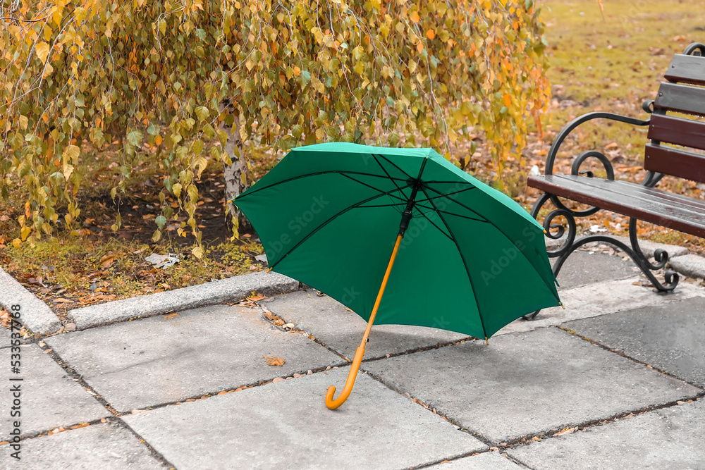 Bright umbrella near bench in park