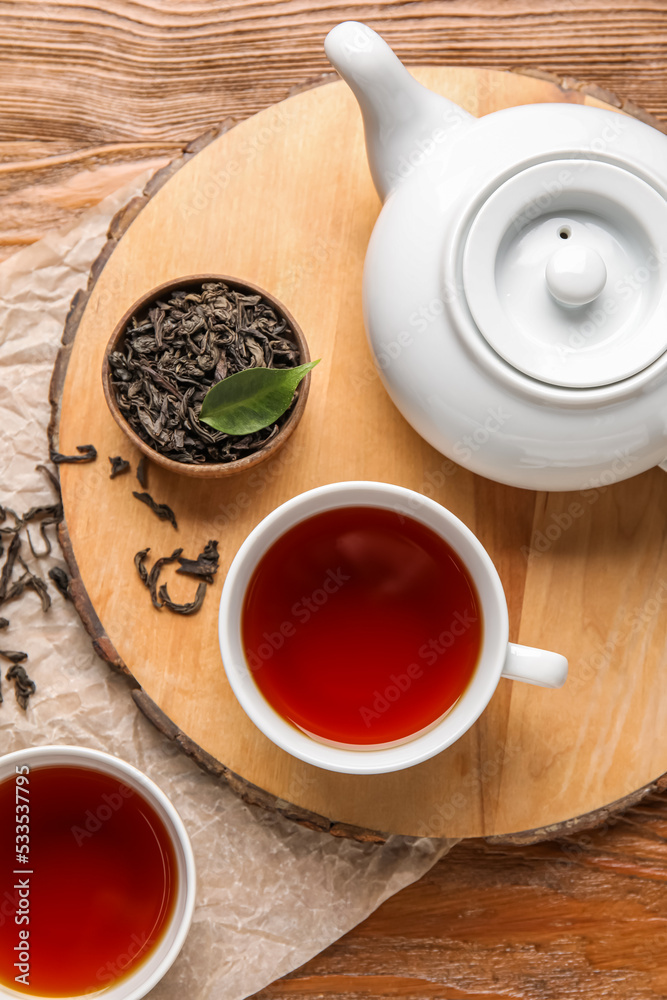 Composition with hot black tea on wooden background