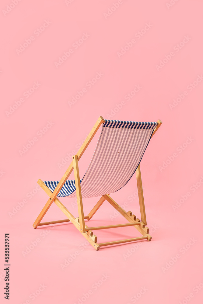 Beach deck chair on pink background