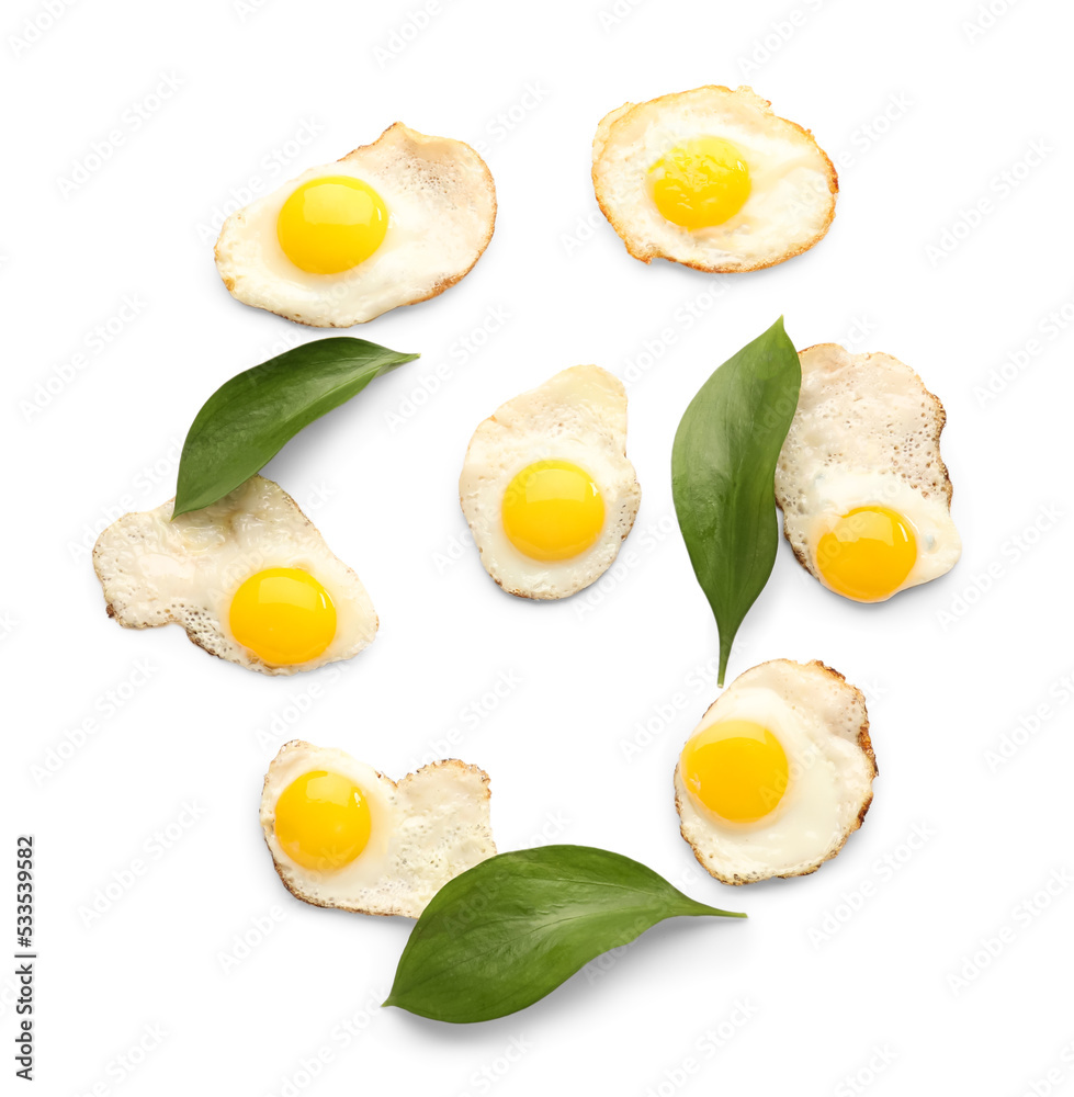 Tasty fried quail eggs and plant leaves on white background