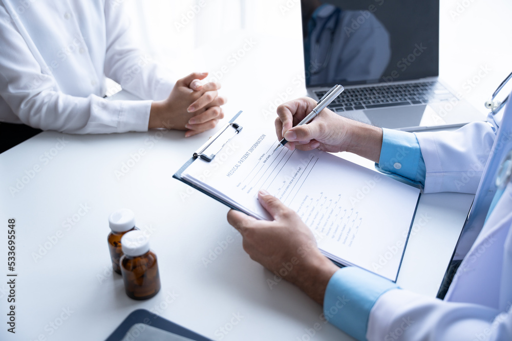 Doctor and patient sitting and talking at medical examination at hospital office, close-up. Therapis