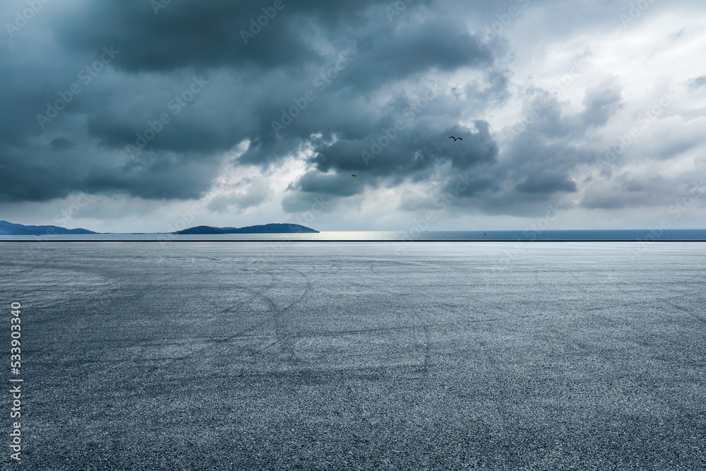 Asphalt road and lake with island nature landscape in cloudy sky