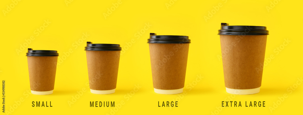 Different sized takeaway coffee cups on yellow background