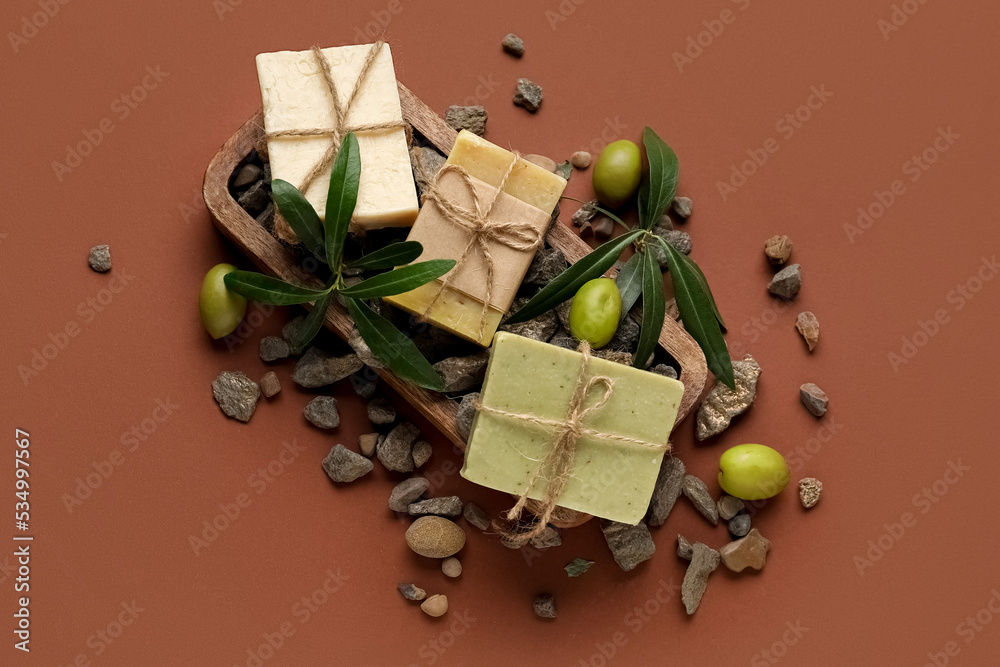 Composition with olive soap bars and stones on color background